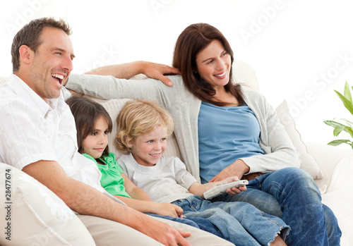 Photo: Happy family watching television together Happy family watching television together