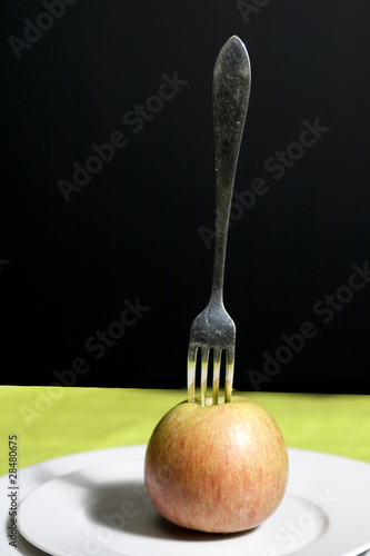 Photo: silver fork picked into apple silver fork picked into apple