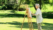 Old woman painting a canvas