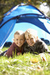 Young children pose outside of tent