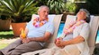 Aged couple relaxing on deckchairs