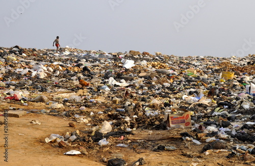 Photo: Kind läuft über Müllkippe in Afrika Kind läuft über Müllkippe in Afrika