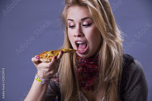 Photo: Girl eating pizza. Girl eating pizza.