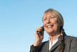 Happy mature businesswoman using cellphone.