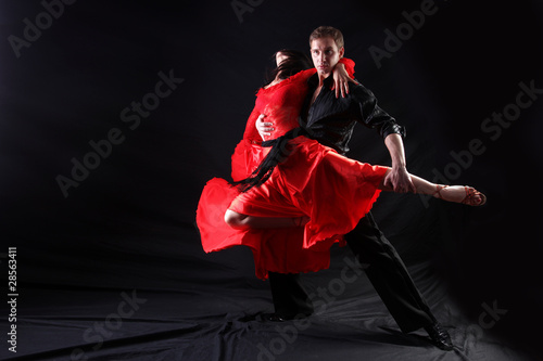 Photo: dancers in action against black background dancers in action against black background