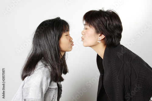 Photo: Teenage girl and her auntie about to kiss each other Teenage girl and her auntie about to kiss each other
