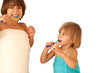 Pretty little sisters brushing their teeth isolated on white
