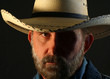 A Bearded Cowboy with Half His Face in Shadow