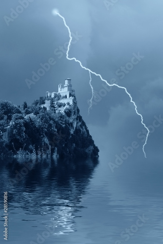 Photo: isolated castle on the rocks over the lake isolated castle on the rocks over the lake