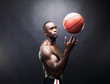 Masculine young male spinning a basketball on finger