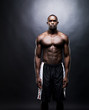 Muscular young guy standing against dark background