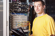 The engineer stand in datacenter near equipment