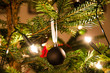 Christmas ball hanging from Christmas tee with lights