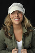 beautiful blond woman in white hat and green shirt smiling