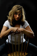 dramatic moody portrait of a young blond woman sitting