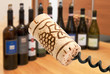 Cork with corkscrew on wine bottles background Cork with corkscrew on wine bottles background