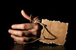 Death. Hand of a corpse on a wooden floor with cardboard