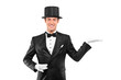Magician wearing top hat with raised left hand Magician wearing top hat with raised left hand