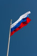 Russian flag on a flagpole against a blue sky Russian flag on a flagpole against a blue sky