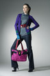 Fashion girl with bag posing in the studio