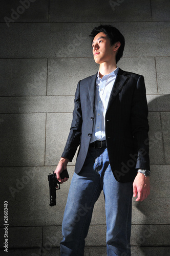 Photo: Asian Man with a Gun in shadow Asian Man with a Gun in shadow