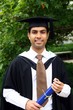 A portrait of a young Indian guy in a graduation gown.