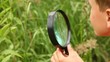 boy is busy by examining nature with a lens