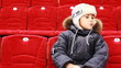 boy sits in armchair, attentively watch hockey match