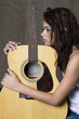 Hugging her guitar