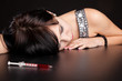 Drug addict woman with syringe is syringe is sleeping on table Drug addict woman with syringe is syringe is sleeping on table