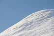 Hügel mit frischem Schnee vor blauem Himmel