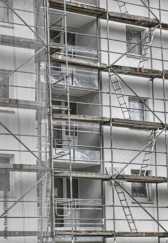 Foto: scaffolding on a building wall. building getting a new paint. scaffolding on a building wall. building getting a new paint.
