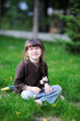Adorable little girl sits on the grass Adorable little girl sits on the grass