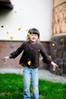 Adorable little girl plays with yellow leaves near the house Adorable little girl plays with yellow leaves near the house