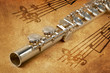 Photo: Silver flute on an ancient musical background Silver flute on an ancient musical background