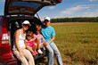 Family of four near their car on vacation