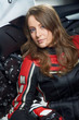 Sexy young woman in a leather jacket and gloves at motorcycle