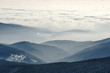 Sea of clouds and coast of foggy hills