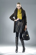 Fashion girl with bag posing in the studio