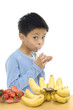 Little boy drinking Milk with banana and apple at the Table