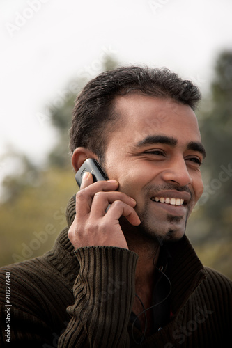 Photo: Indian man Busy on cell phone Indian man Busy on cell phone