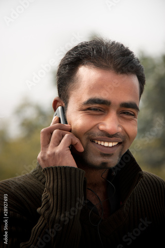 Photo: Indian man Busy on cell phone Indian man Busy on cell phone