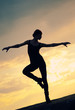 Silhouette of dancing woman over sunset. Yoga
