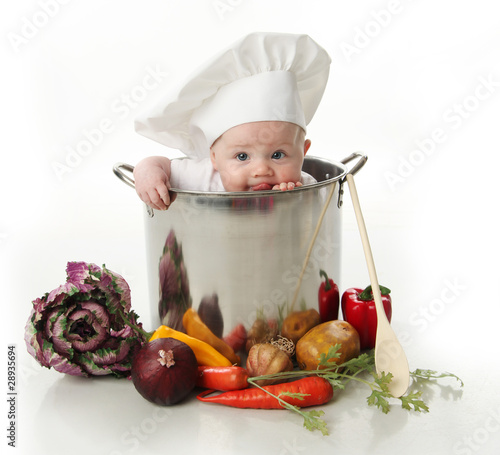 Foto: Licking baby sitting in a chef's pot Licking baby sitting in a chef's pot