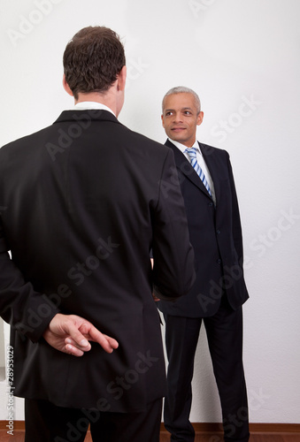 Photo: Crossed Fingers At Handshake Crossed Fingers At Handshake