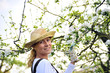 Young woman gardening - in apple tree orchard