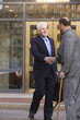 Two businessmen shaking hands in front of the bank