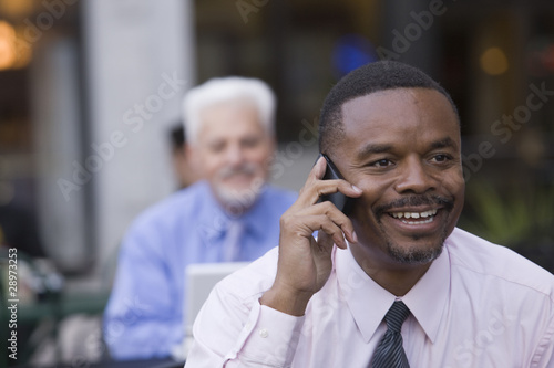 Photo: Businessmen working at a cafe Businessmen working at a cafe