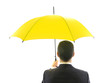 Businessman with yellow umbrella - protection concept.