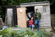 A young couple having a break on an allotment, drinking wine